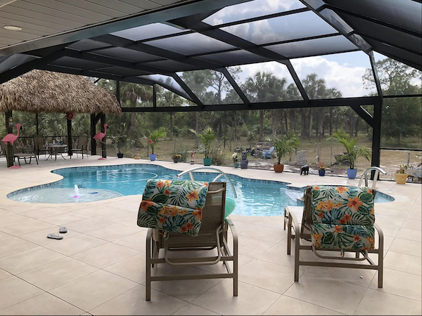 Gulf Shore Pools pool with screened enclosure. and 2 chairs